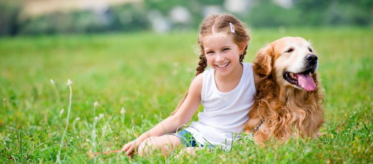 ein Mädchen mit einem Hund auf einer Wiese